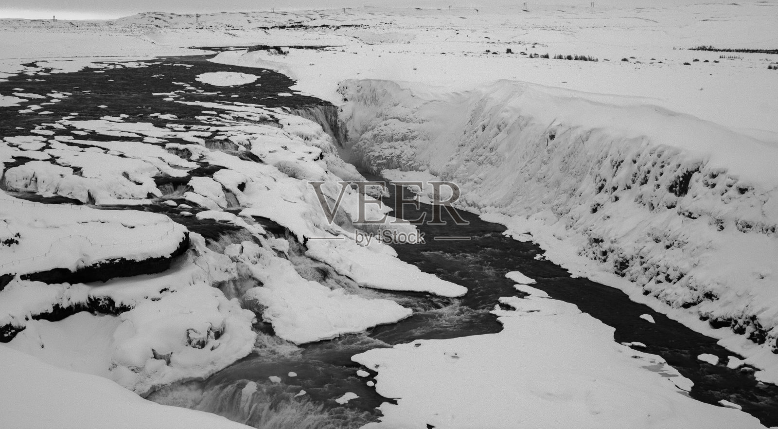 小溪在冰岛的荒野中流淌,风景被雪覆盖照片摄影图片