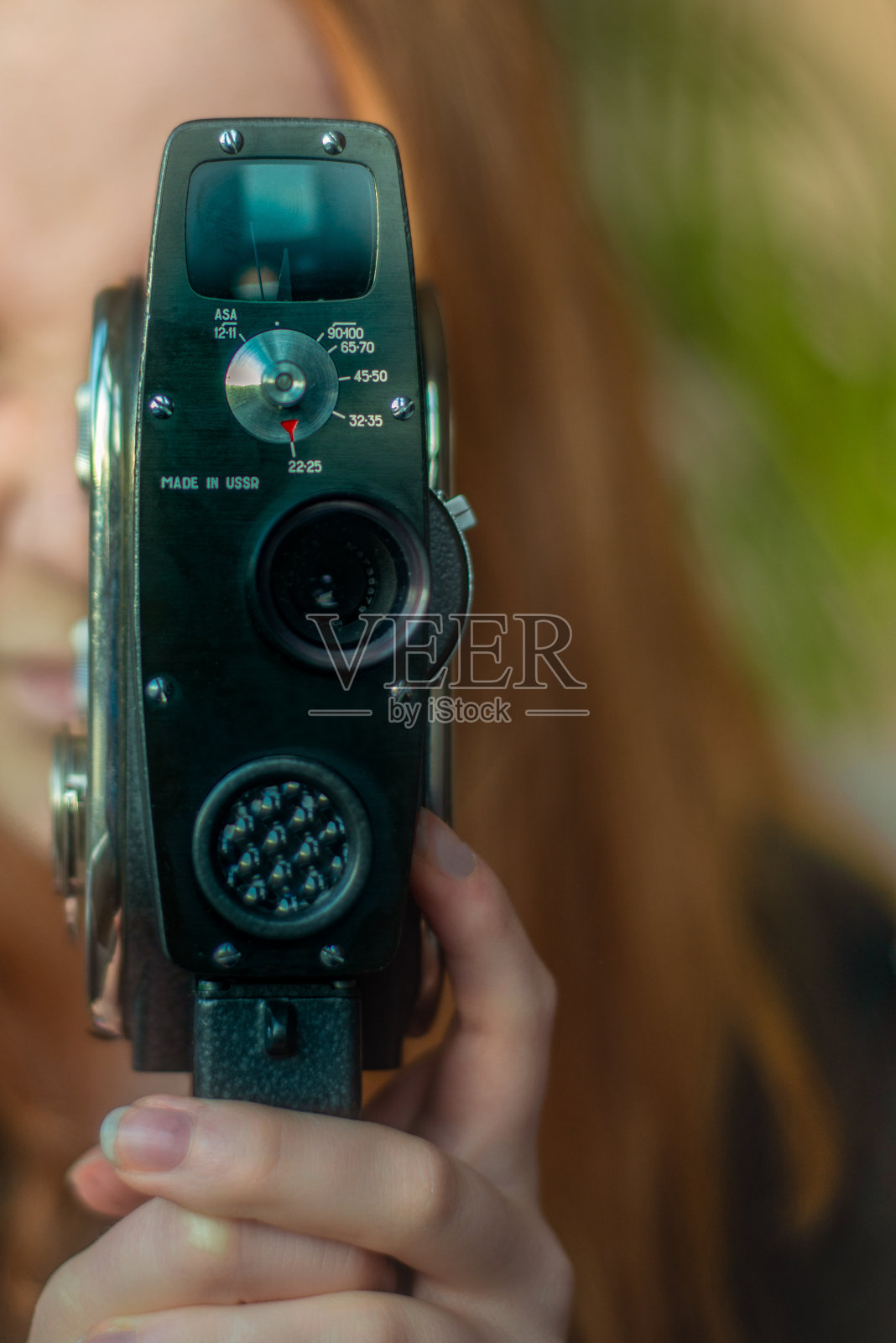 年轻女性电影制作人拍摄与复古超级8电影摄影机照片摄影图片