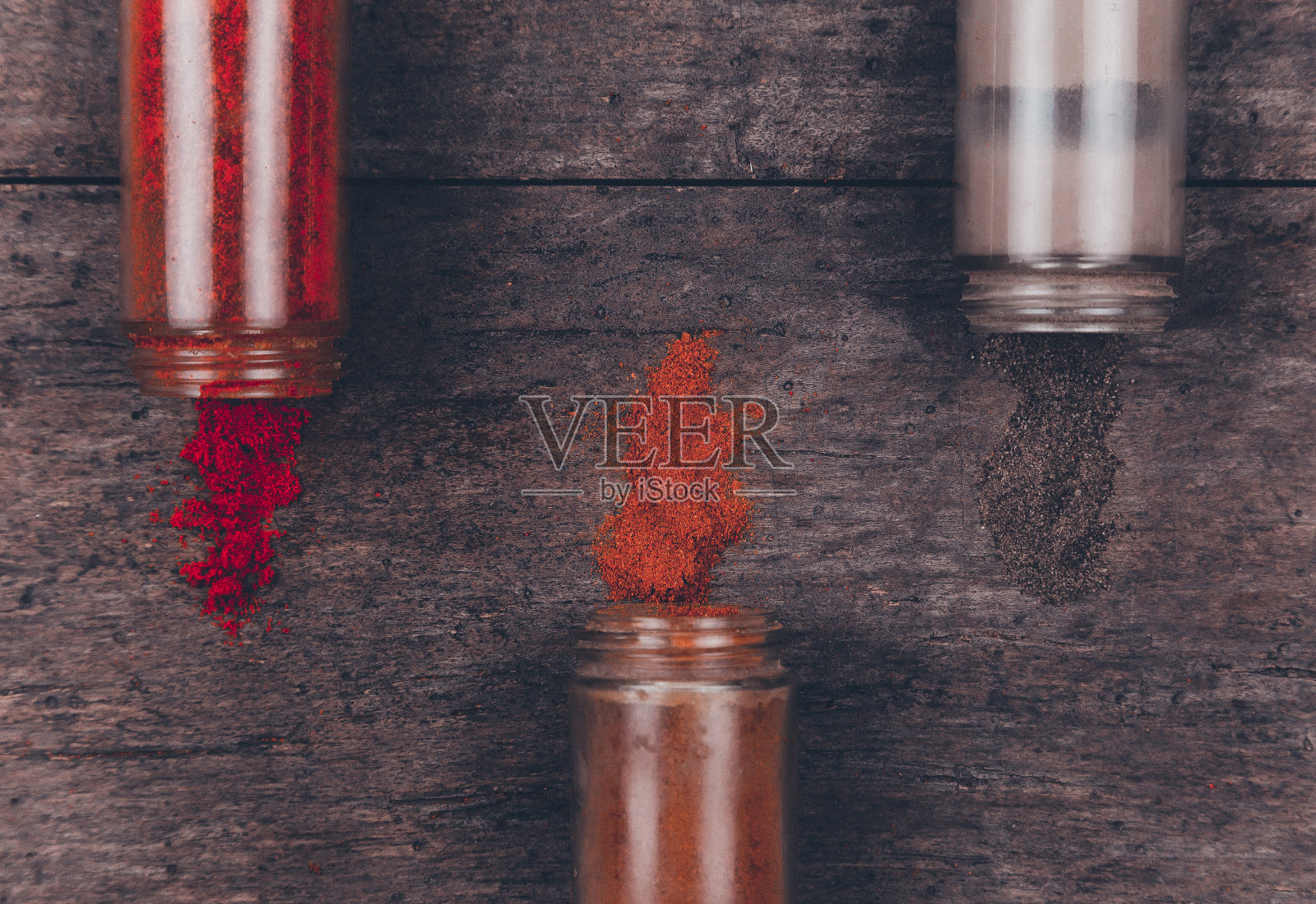 辣椒彩色粉末香料分散在瓶子上的木制背景照片摄影图片