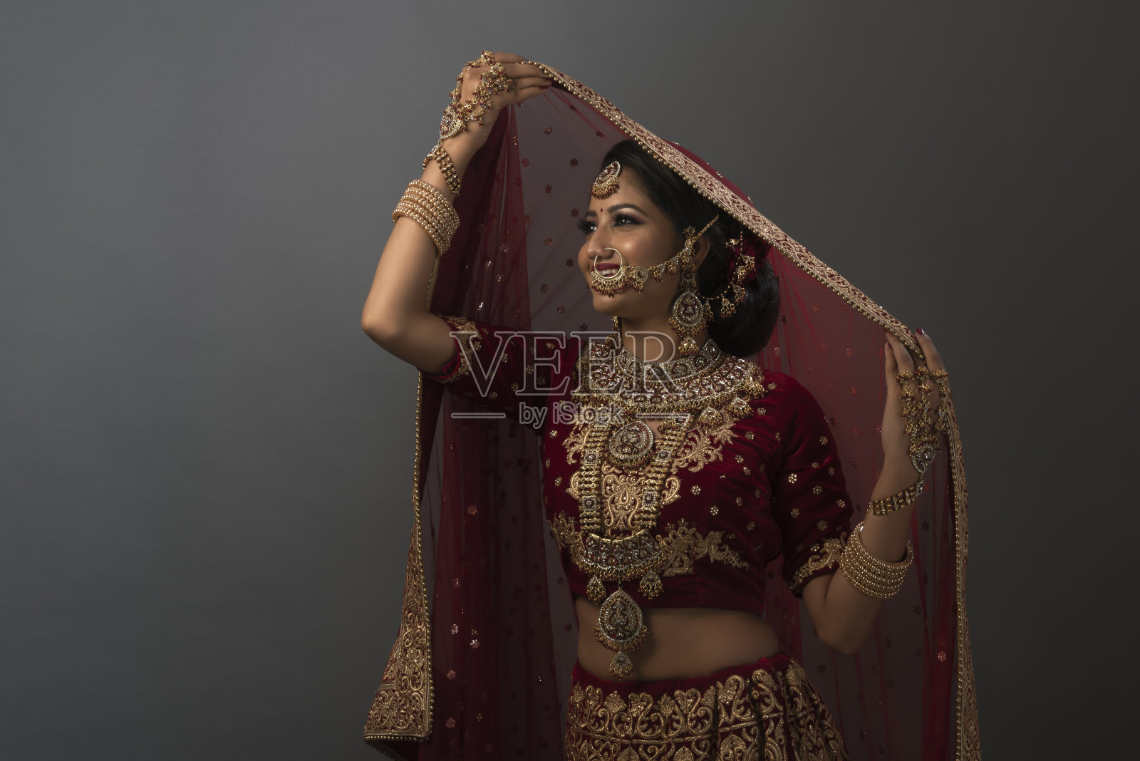 年轻的印度妇女穿着婚纱,戴着珠宝,化妆照片摄影图片