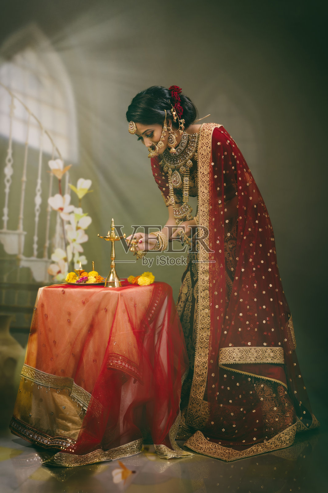年轻的印度妇女穿着婚纱,戴着珠宝,化妆照片摄影图片
