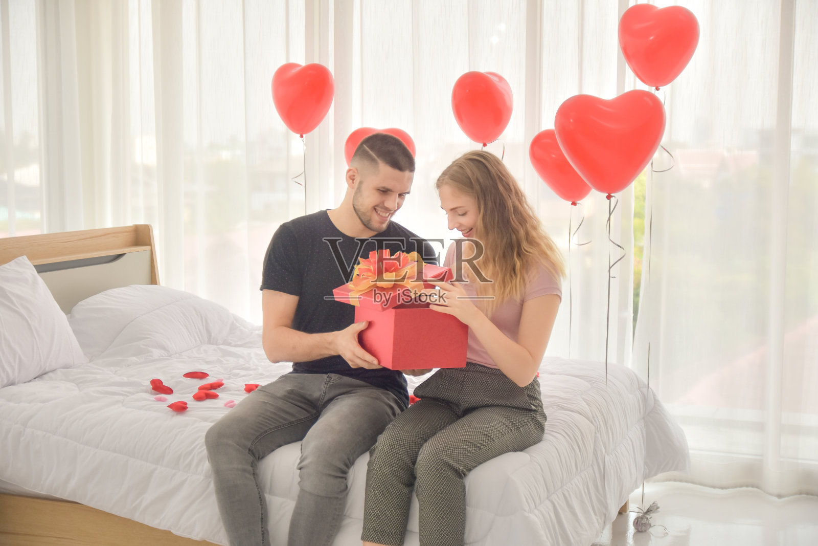 情侣在卧室赠送礼盒,爱意浓浓情人节概念照片摄影图片