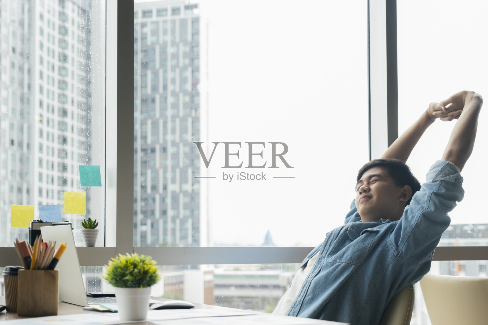 年轻人在办公室放松伸展身体照片摄影图片