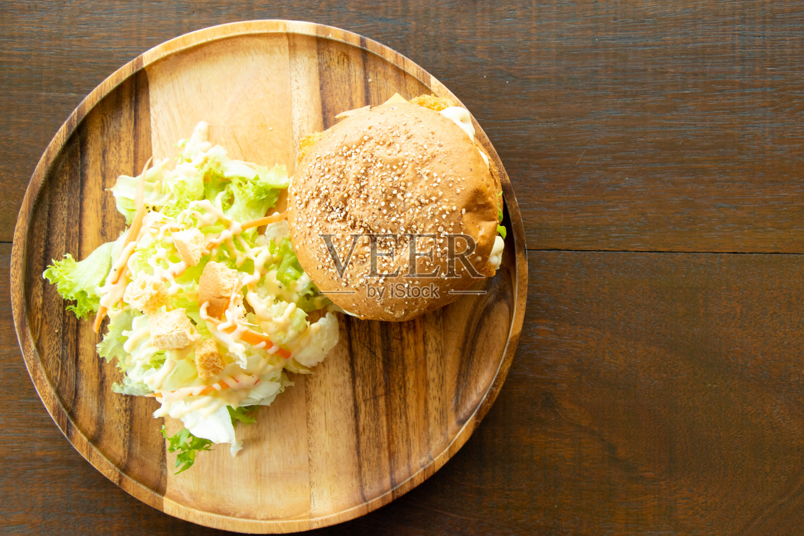 炸鱼片汉堡与蔬菜沙拉在木盘子的背景照片摄影图片