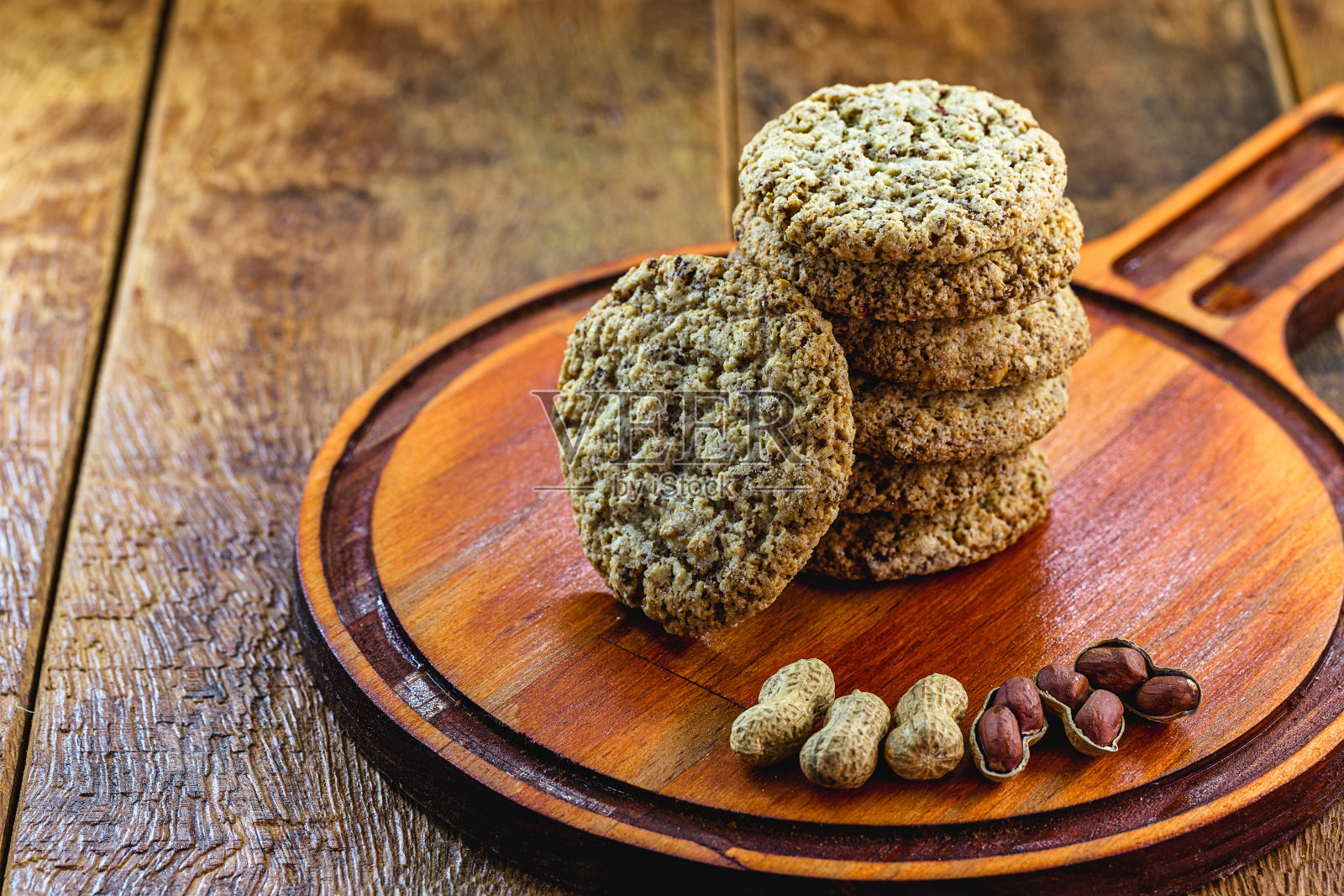 用有机花生自制的饼干。素食饼干在乡村木制背景。照片摄影图片