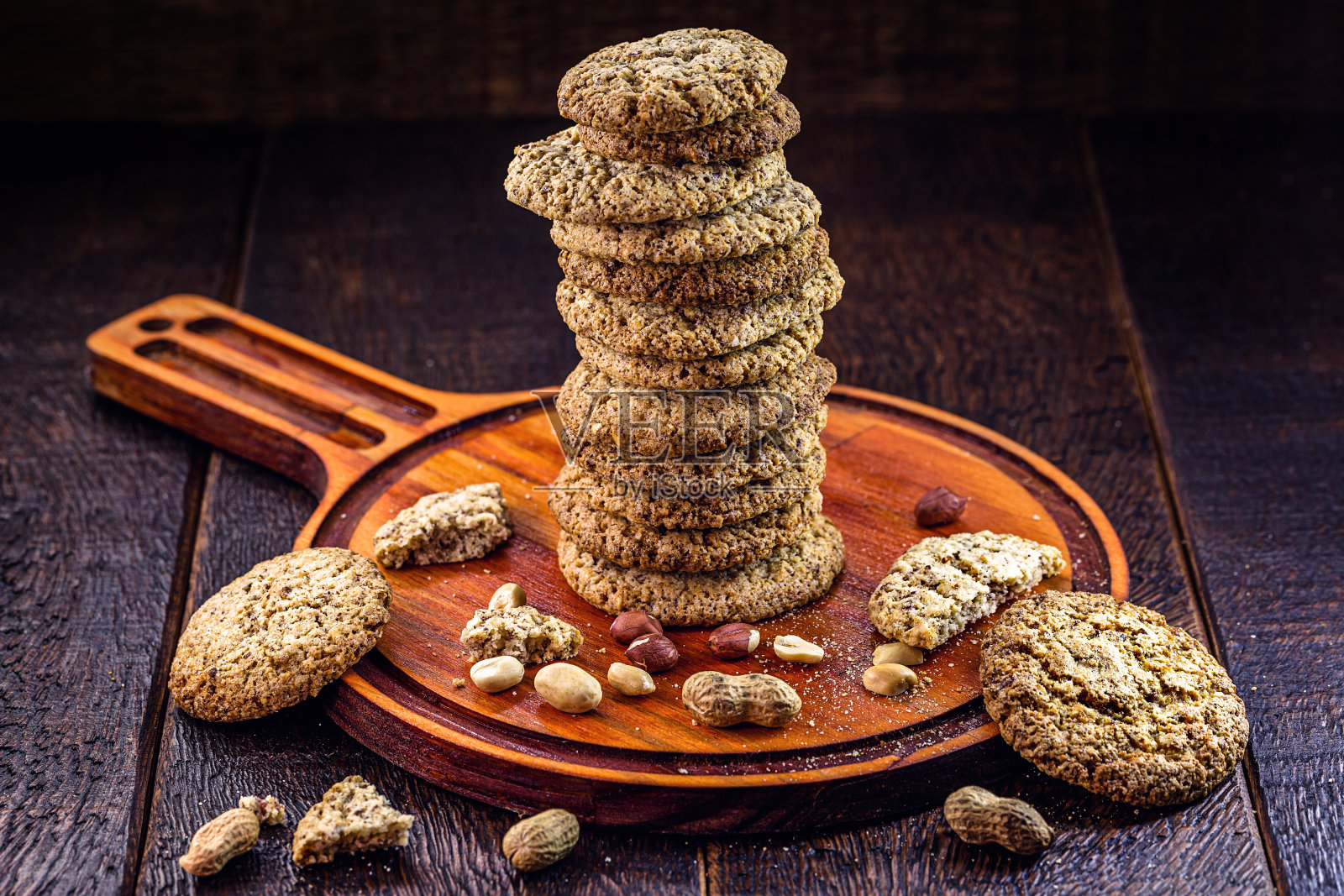 自制的花生饼干,堆放在质朴的杏仁桌上。健康的理念脱颖而出。照片摄影图片