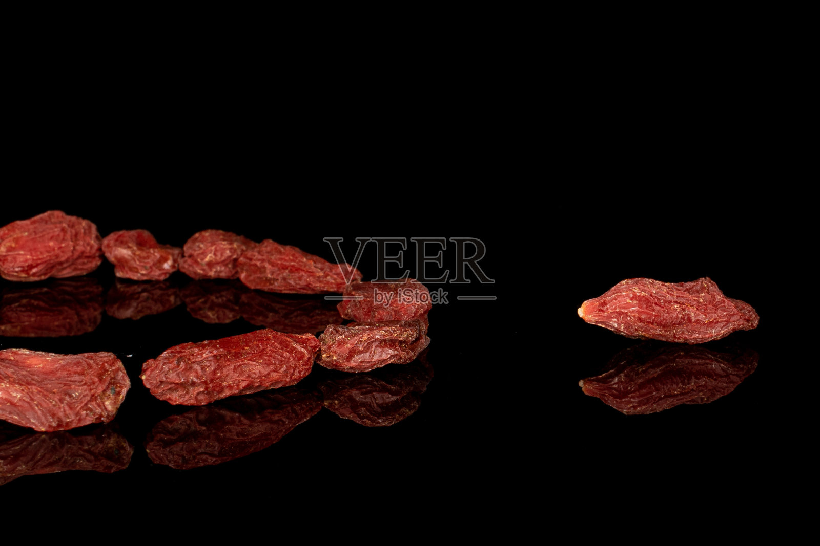 红色干燥的枸杞孤立在黑色玻璃上照片摄影图片