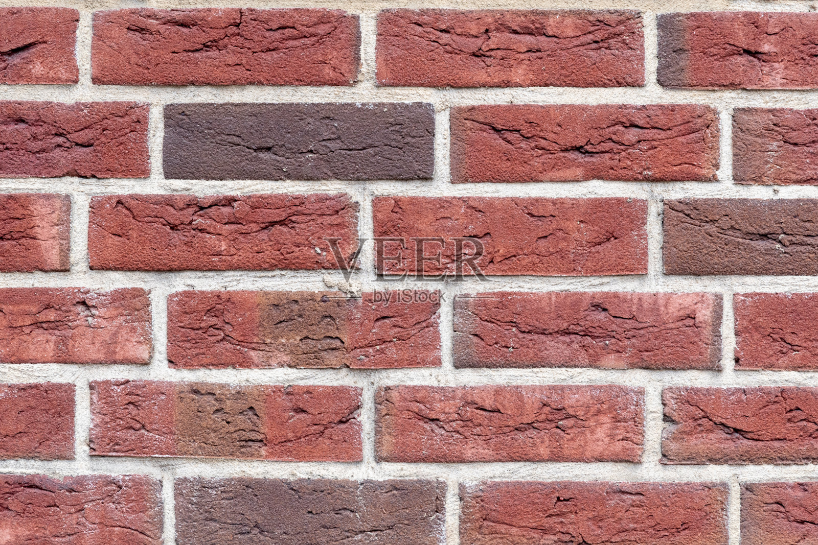 在自然光下由烤砖制成的旧建筑的墙壁碎片。照片摄影图片