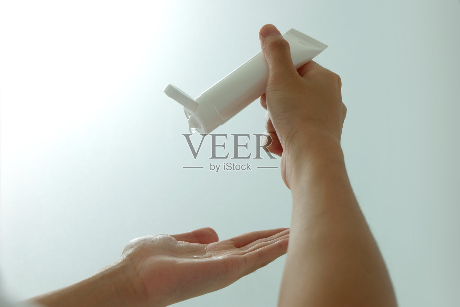 用洗手液消毒手。用凝胶管清洗双手。照片摄影图片