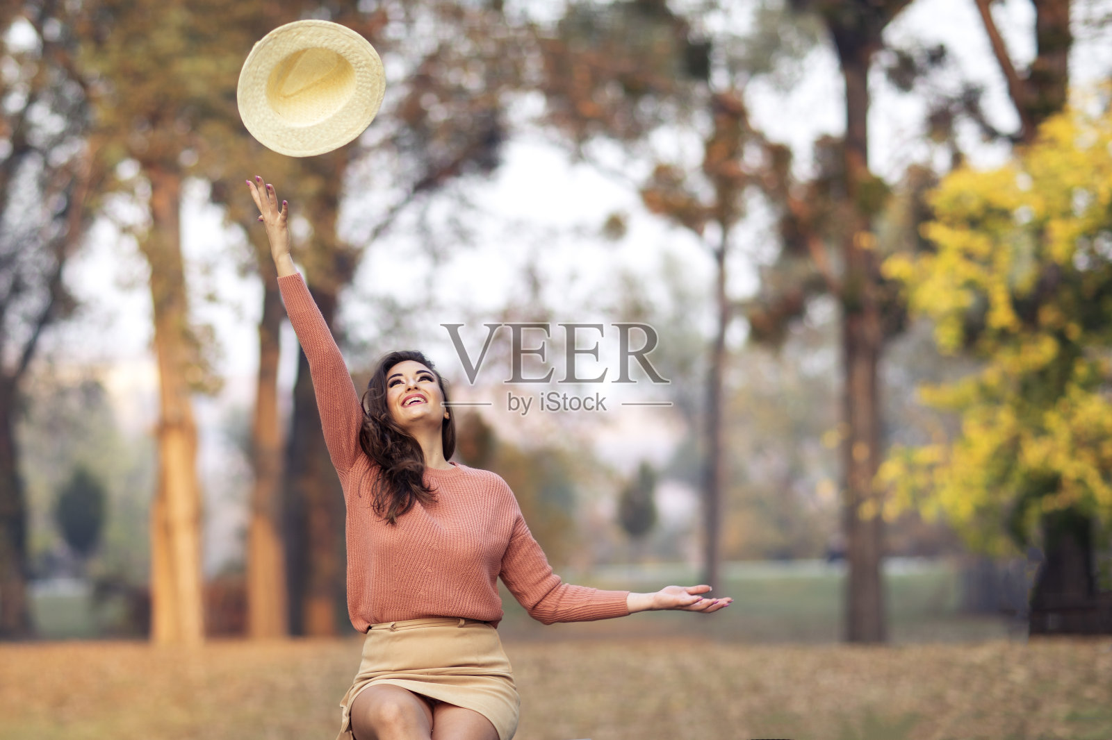 一个年轻美丽的女人的肖像,她正在玩帽子照片摄影图片