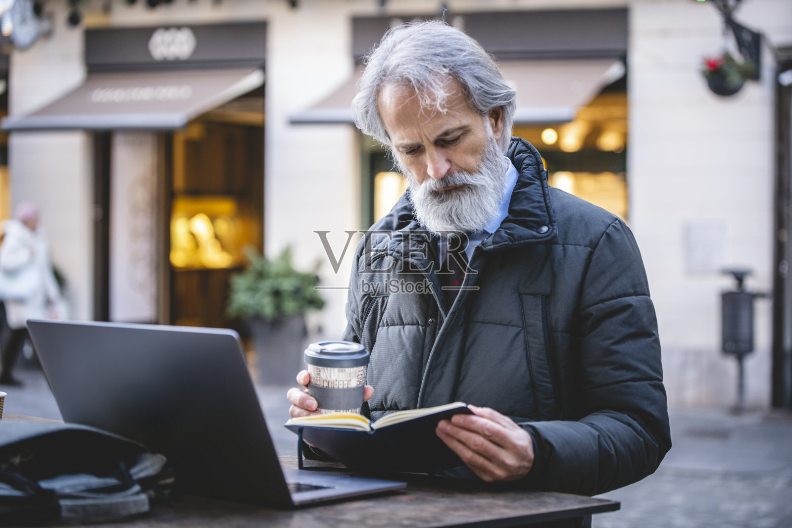 一个在户外酒吧里用笔记本电脑工作的商人照片摄影图片