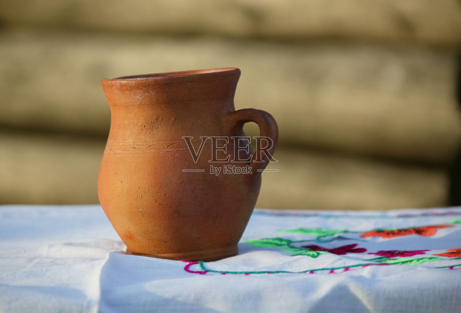 复古陶罐的背景刺绣衬衫。照片摄影图片