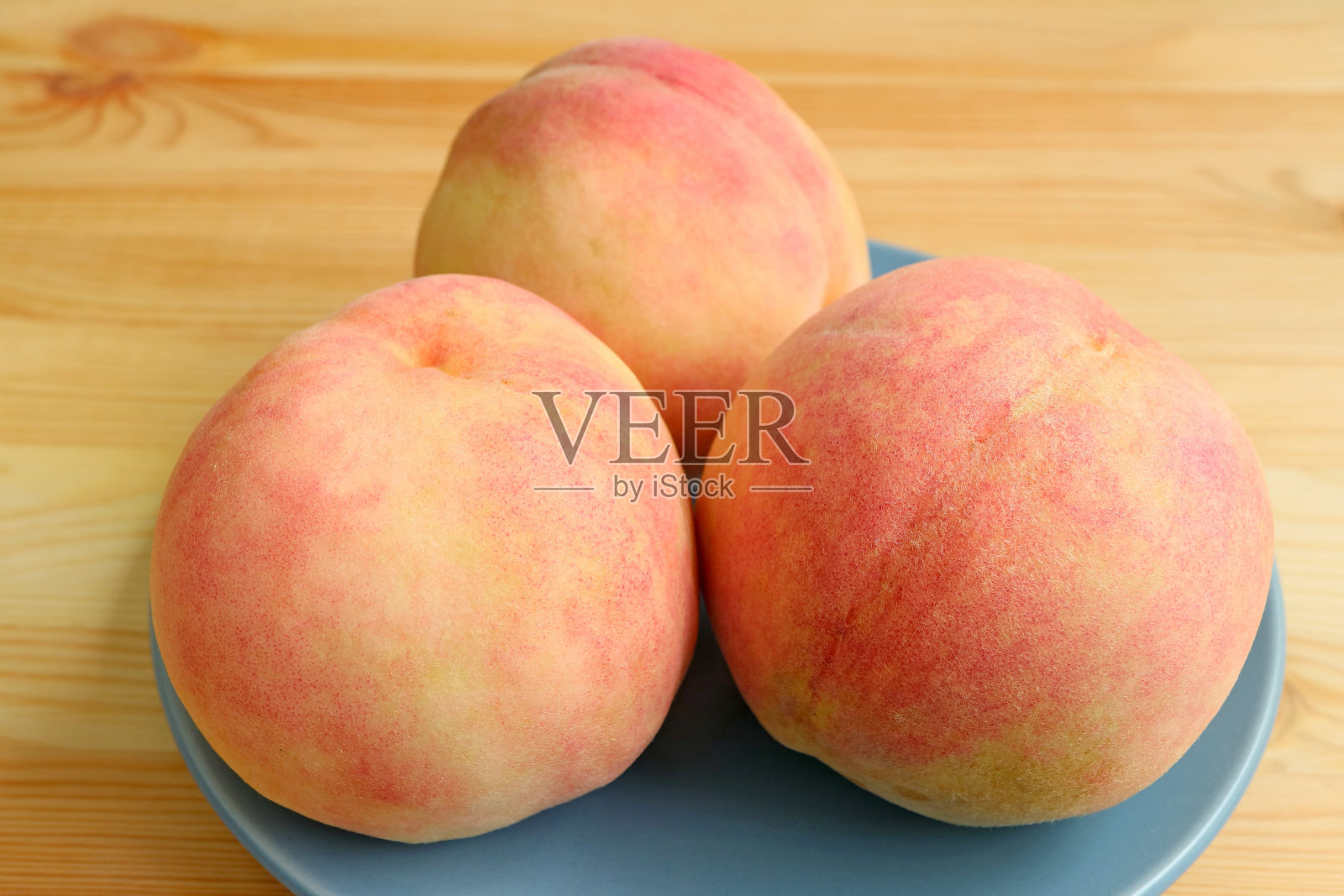 木桌上放着三盘熟透的新鲜桃子照片摄影图片