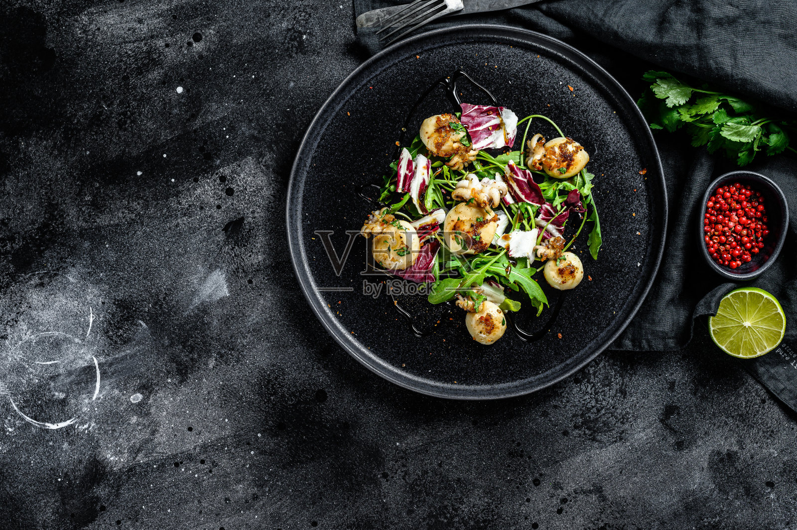 泰式沙拉配烤鱿鱼和芝麻菜。黑色背景。前视图。本空间照片摄影图片