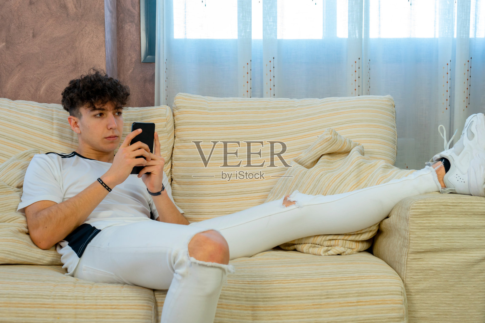 一个年轻人在白色沙发上摆姿势照片摄影图片