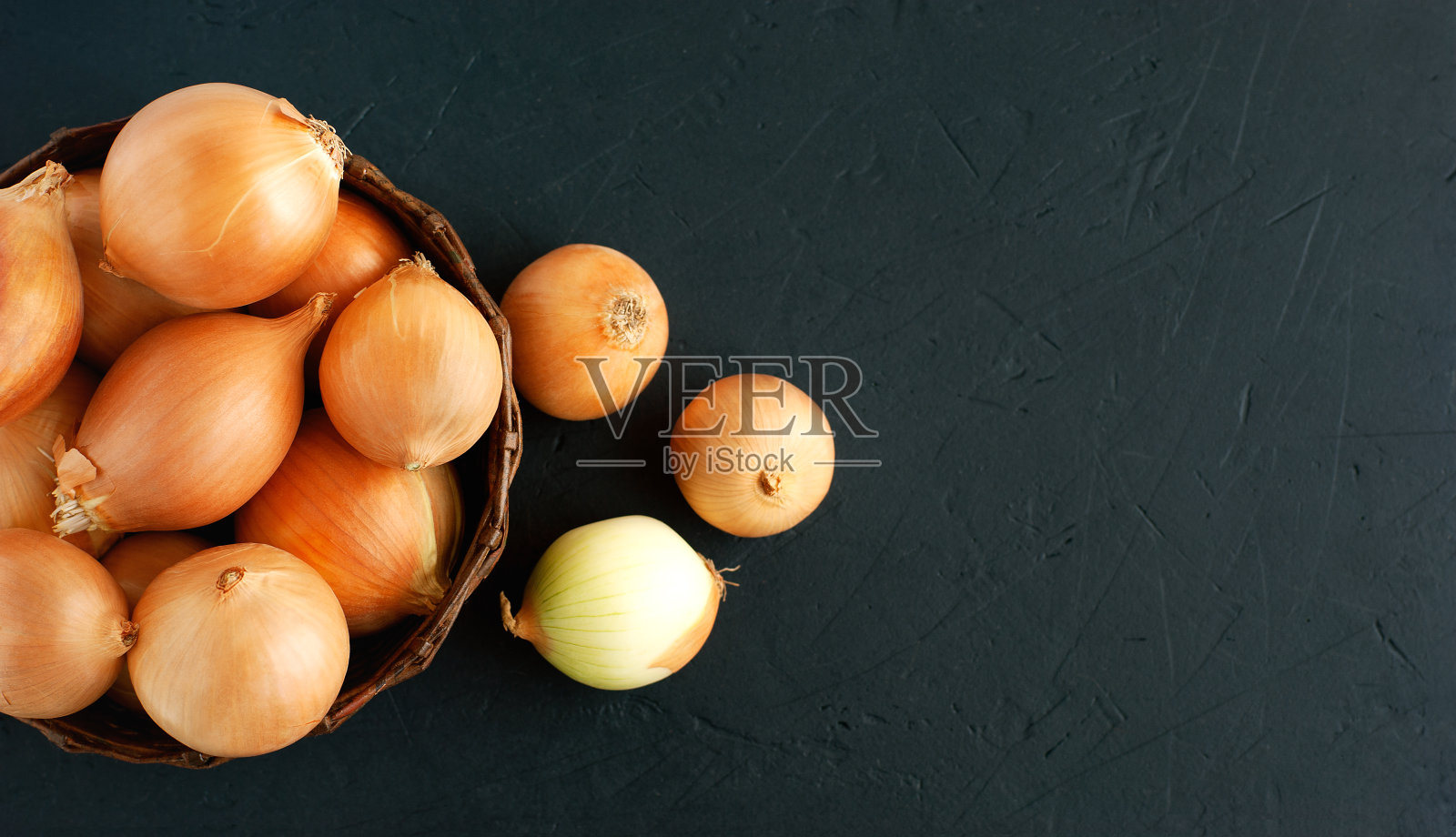 篮子里的洋葱,背景是黑色。照片摄影图片