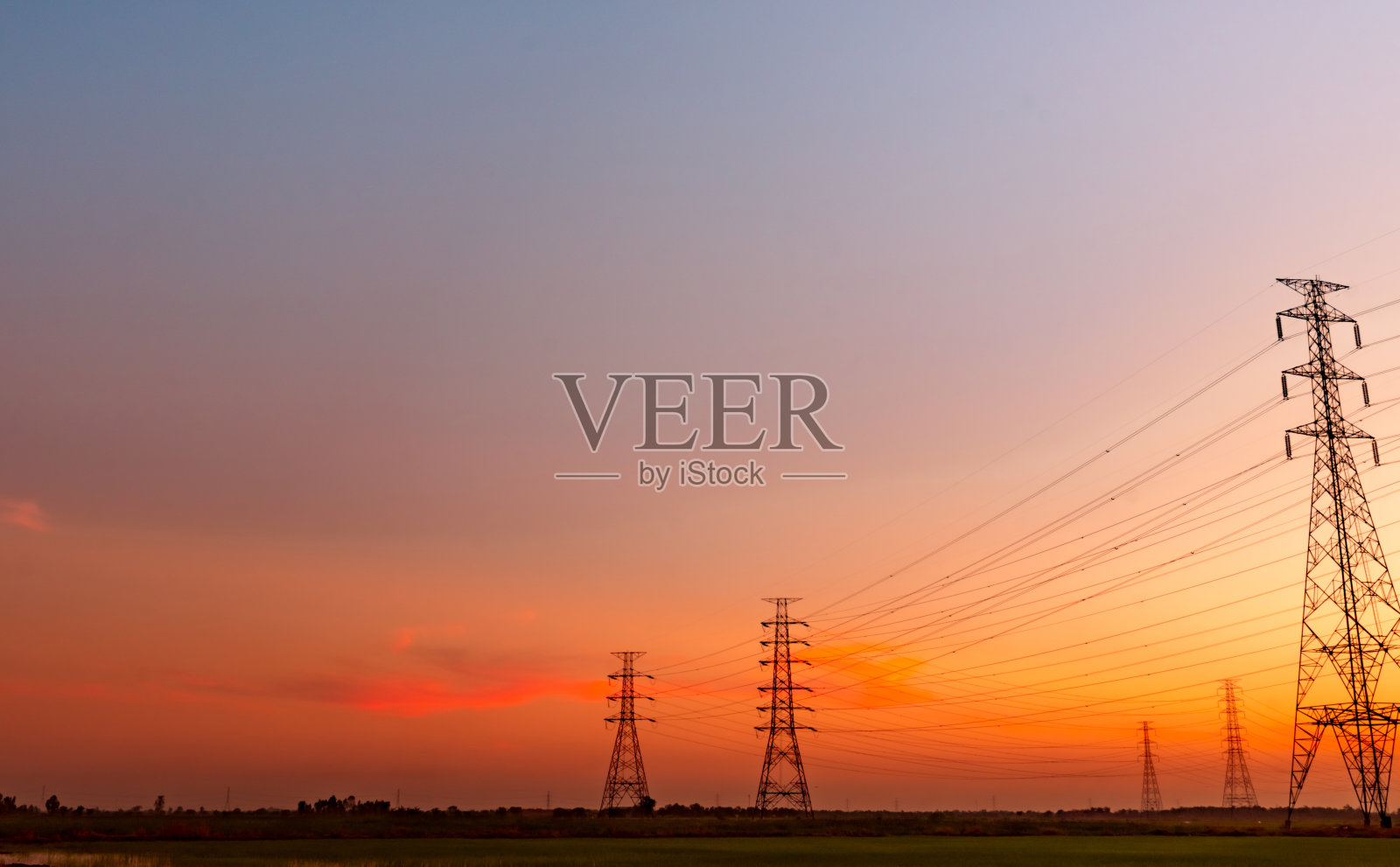 高压塔和电线与日落的天空。电力波兰人。动力和能源概念。高压电网塔架带电线电缆。美丽的风景与紫色负载红色的天空。照片摄影图片