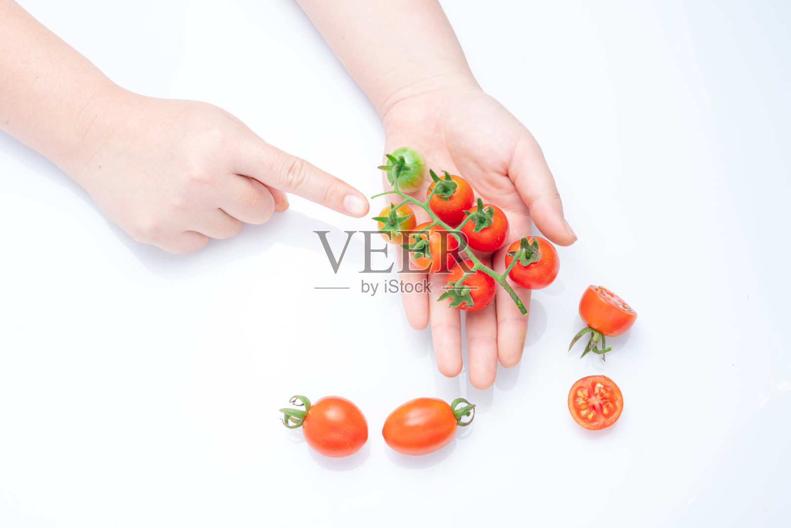 在餐桌上拿着西红柿和成熟的樱桃西红柿。照片摄影图片