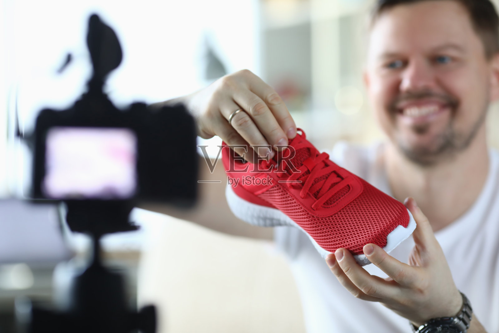 男人在摄像机前展示运动鞋概览照片摄影图片