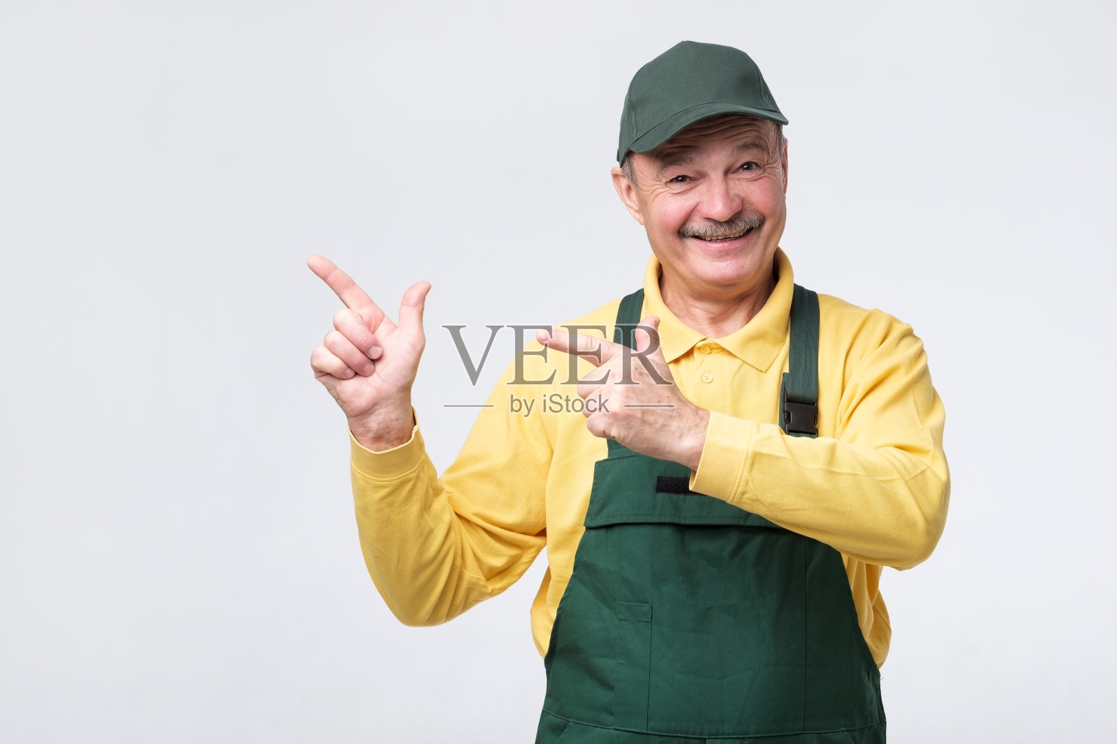 戴着帽子和防护服的工人用手指指向一旁照片摄影图片