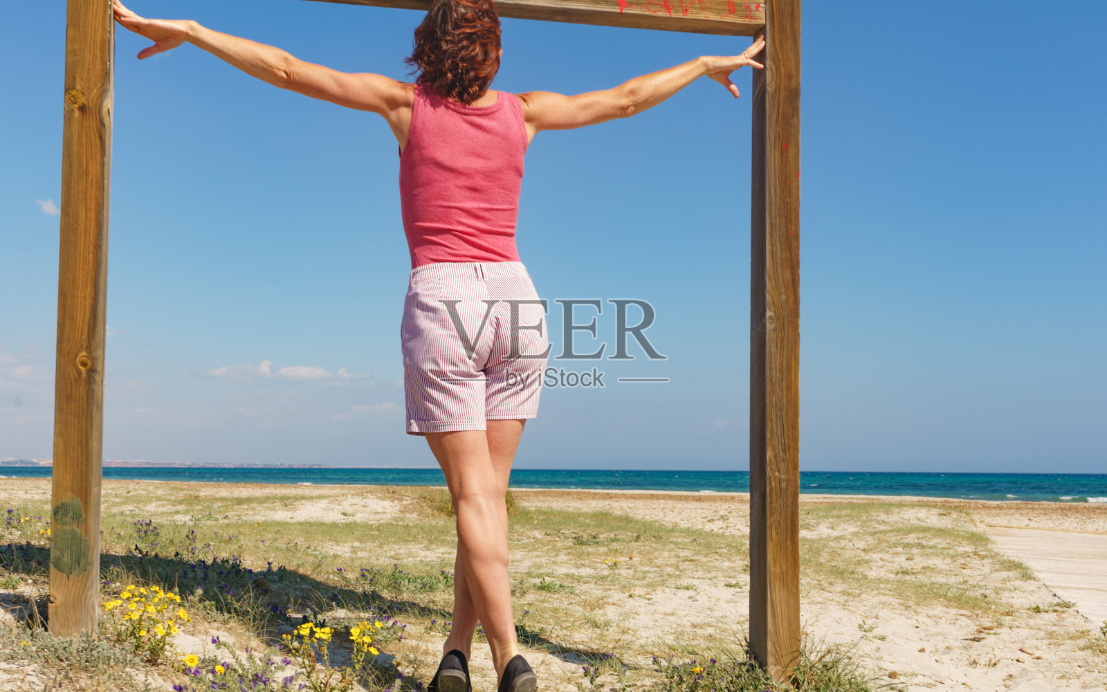 在西班牙海滩上散步的女人照片摄影图片