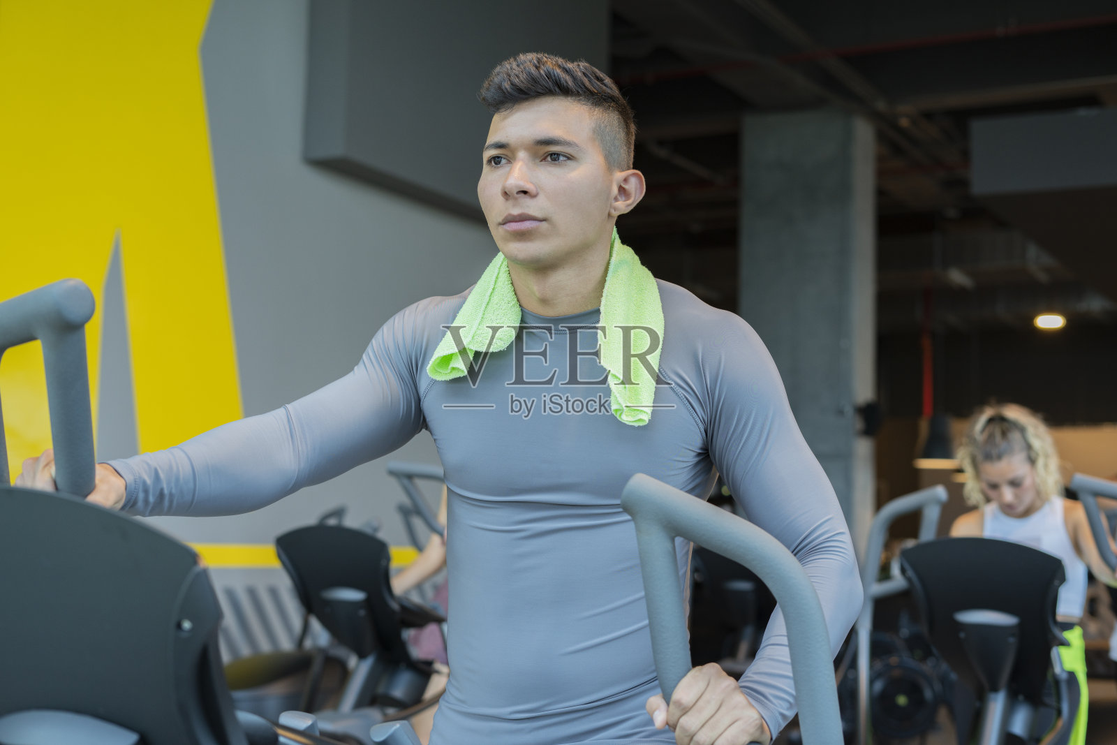 拉丁美洲男人在健身房的椭圆机上锻炼照片摄影图片