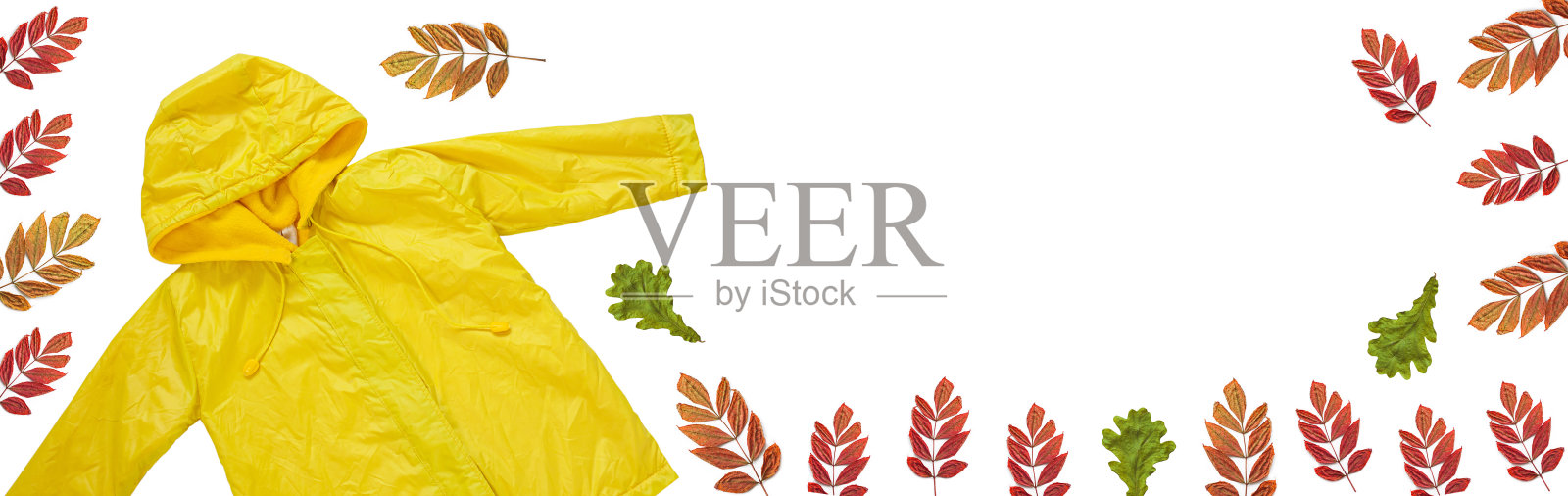 黄色雨衣在白色背景孤立。快乐有趣的孩子胜过秋天的风格的衣服。快乐下雨天概念照片摄影图片