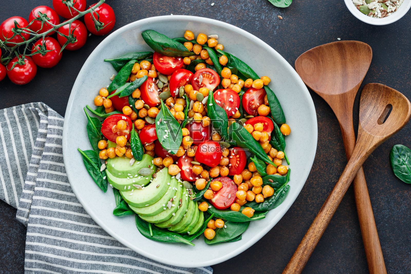 新鲜的健康沙拉,鹰嘴豆,鳄梨,圣女果和菠菜。照片摄影图片
