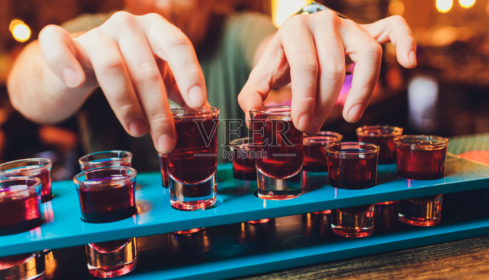 酒保用朗姆酒和烈酒调制酒精饮料。照片摄影图片