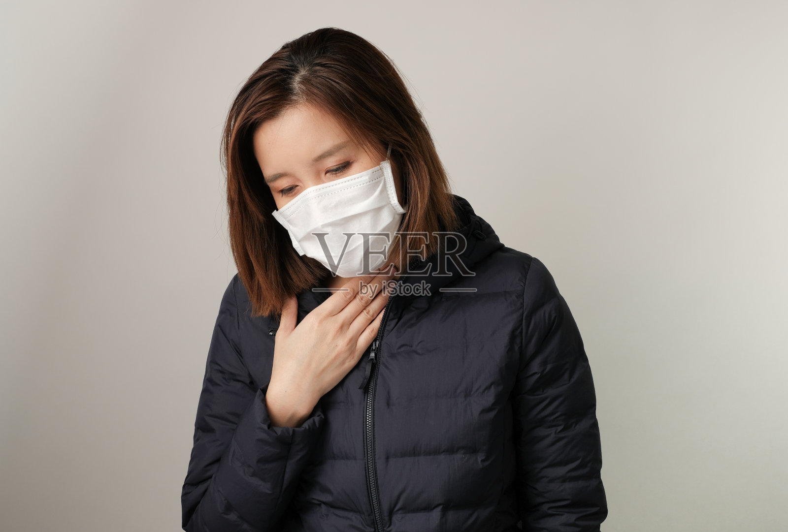 亚洲女人喉咙痛,戴医用口罩以保护和抵抗细菌、新冠病毒、SARS和流感病毒的感染照片摄影图片
