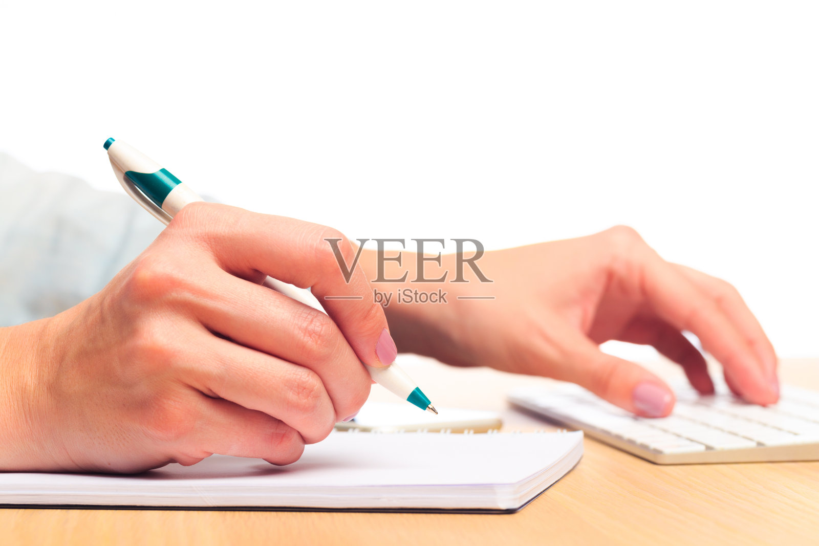 女人的手在笔记本上写字。办公的地方照片摄影图片