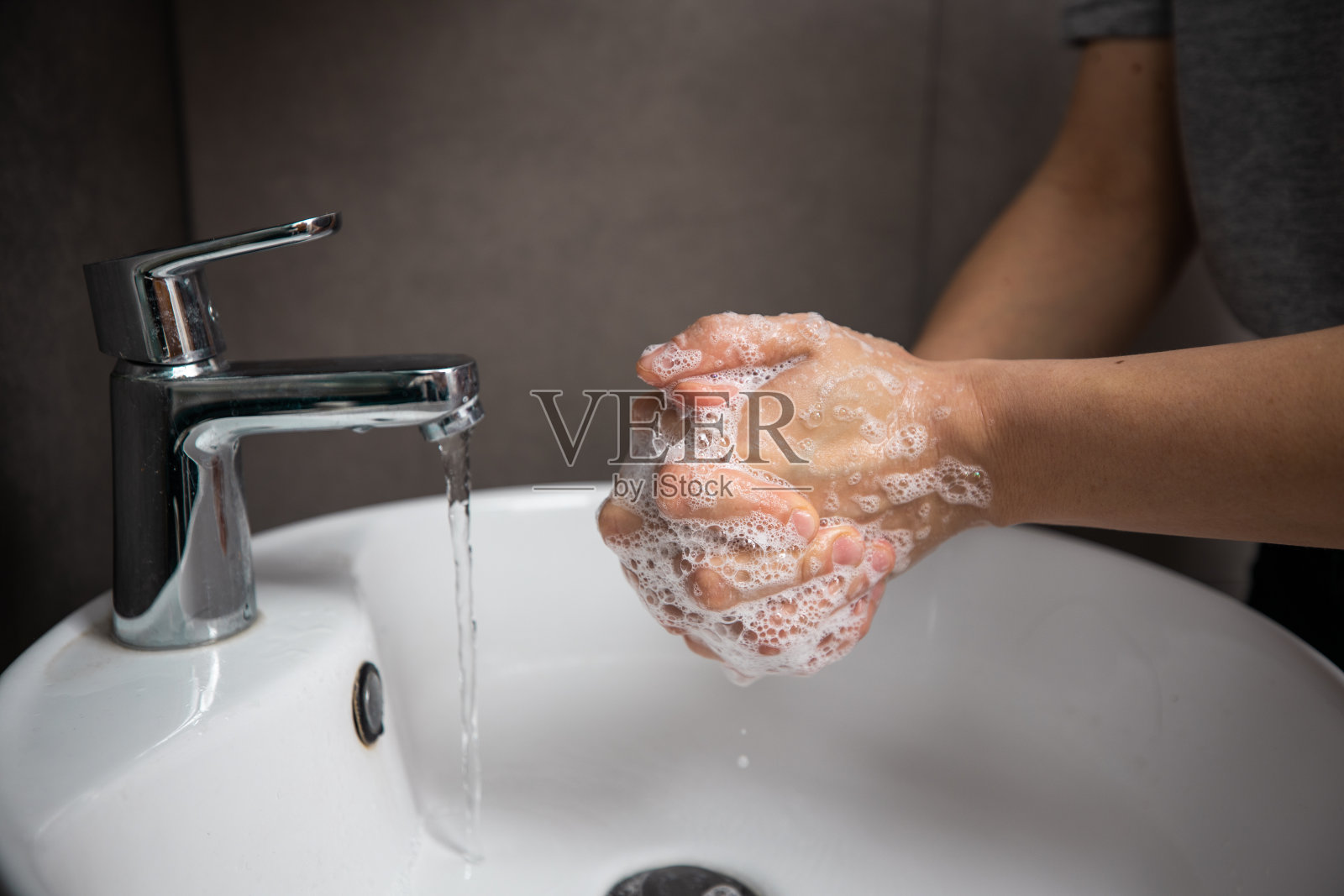 年轻女子在浴室洗手进行预防照片摄影图片