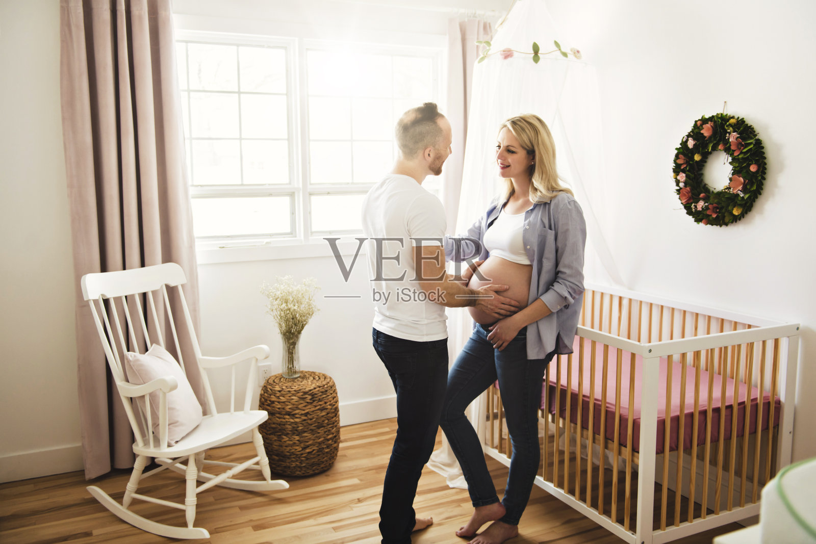 怀孕的母亲和丈夫在家中婴儿房照片摄影图片
