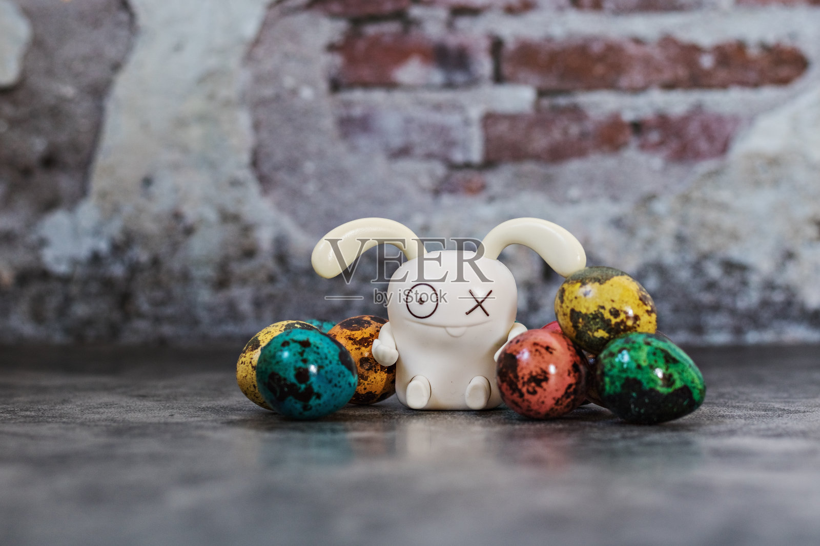 复活节快乐,鹌鹑在蓝色混凝土背景的木碗里画斑点蛋,兔子,春天东正教和天主教节日的象征照片摄影图片