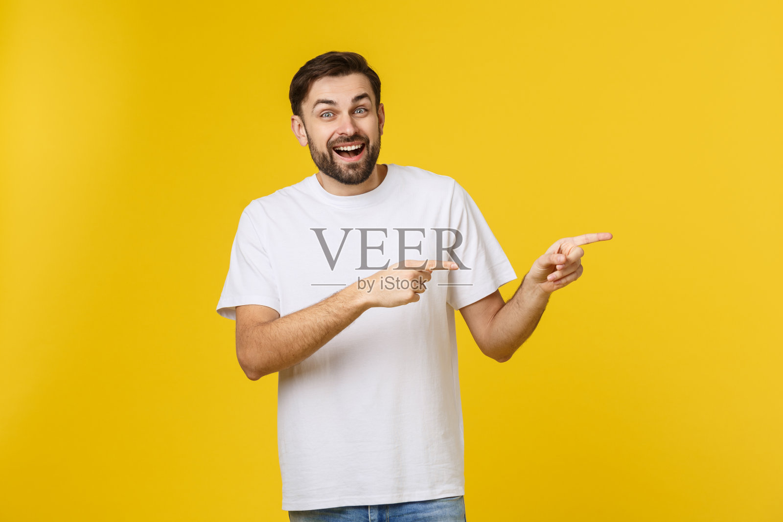 休闲白人男子指向黄色背景上的空白区域照片摄影图片