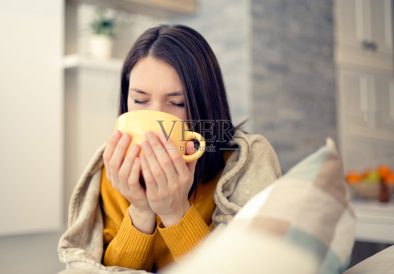 生病的年轻女人在家中喝茶盖毯照片摄影图片