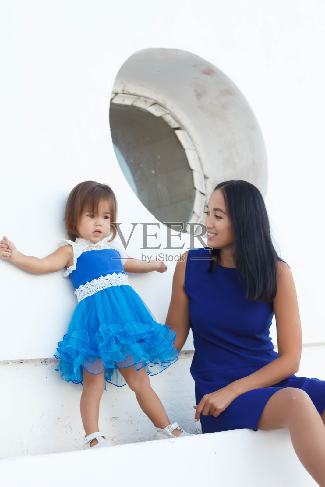 穿着蓝色连衣裙的快乐母女在散步照片摄影图片