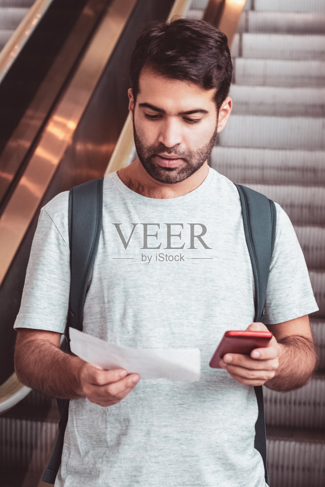 专注的年轻人拿着票和智能手机照片摄影图片