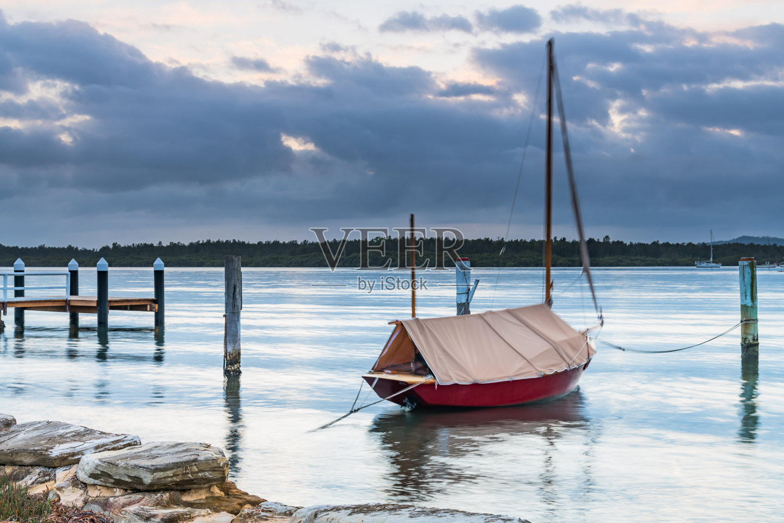 小红船和海湾上的多云日出照片摄影图片