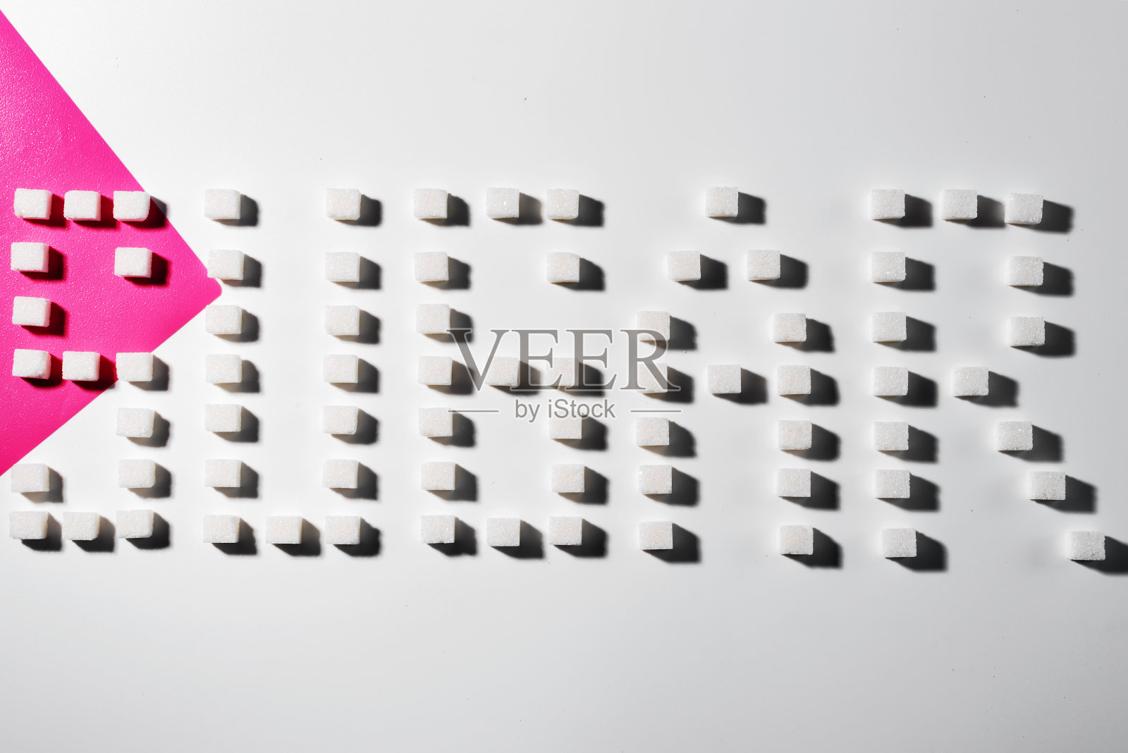 白粉背景上的方糖按几何顺序排列。“糖”这个词。照片摄影图片