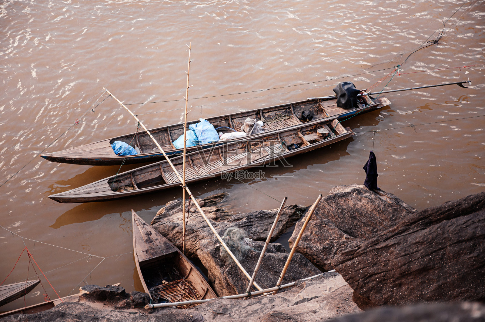 砂岩峡谷悬崖的湄公河海岸线和当地的泰国渔船照片摄影图片