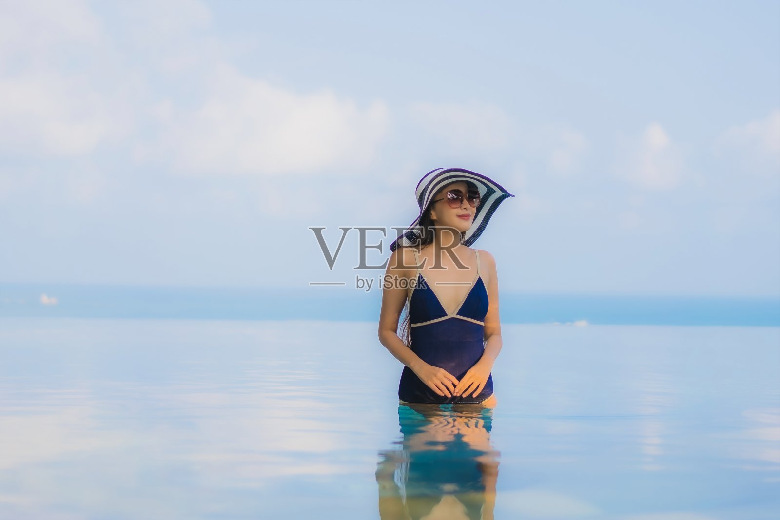 年轻亚洲女性在酒店泳池边放松身姿照片摄影图片