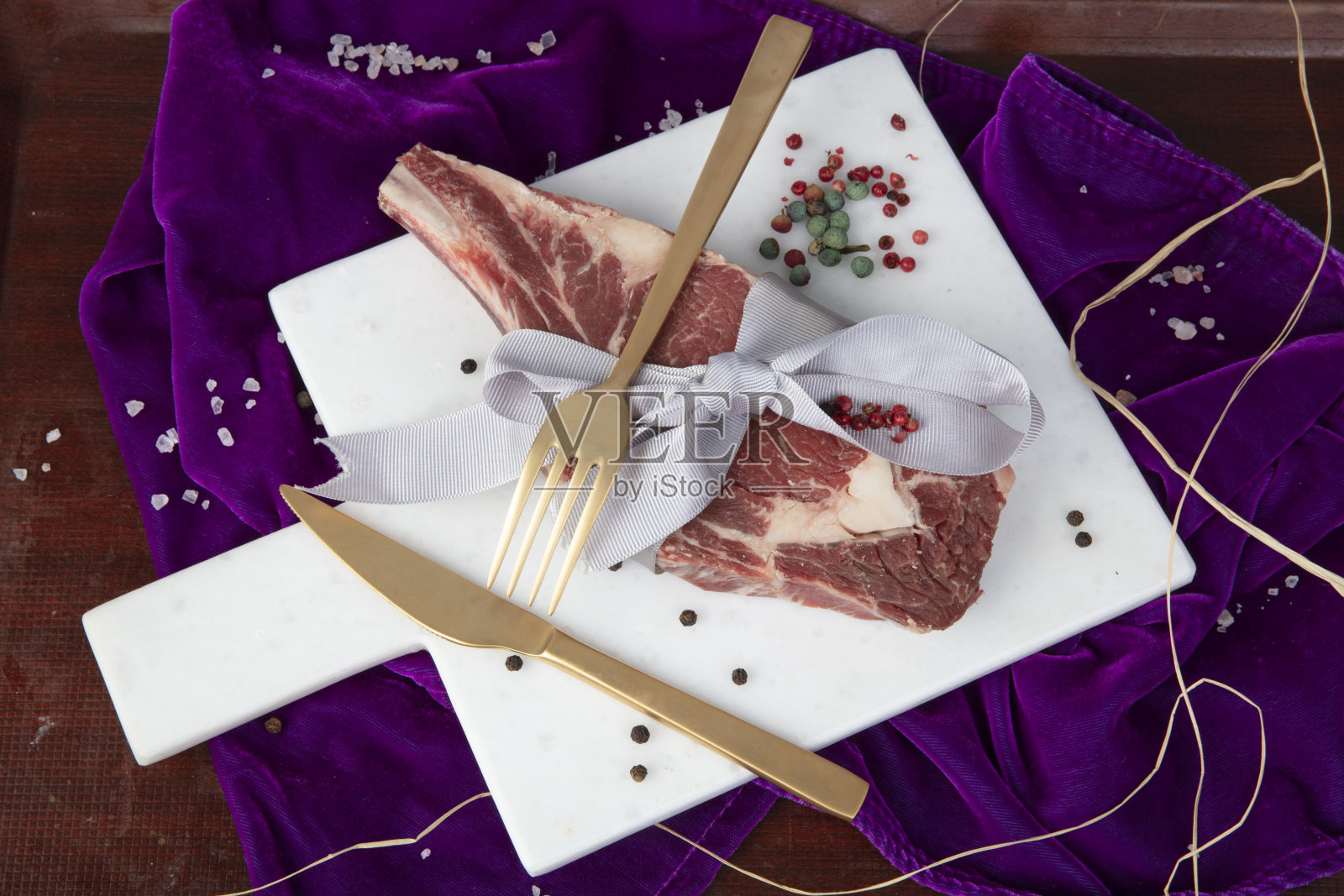 情人节惊喜的概念。大理石地板上的生牛扒,牛肋。照片摄影图片