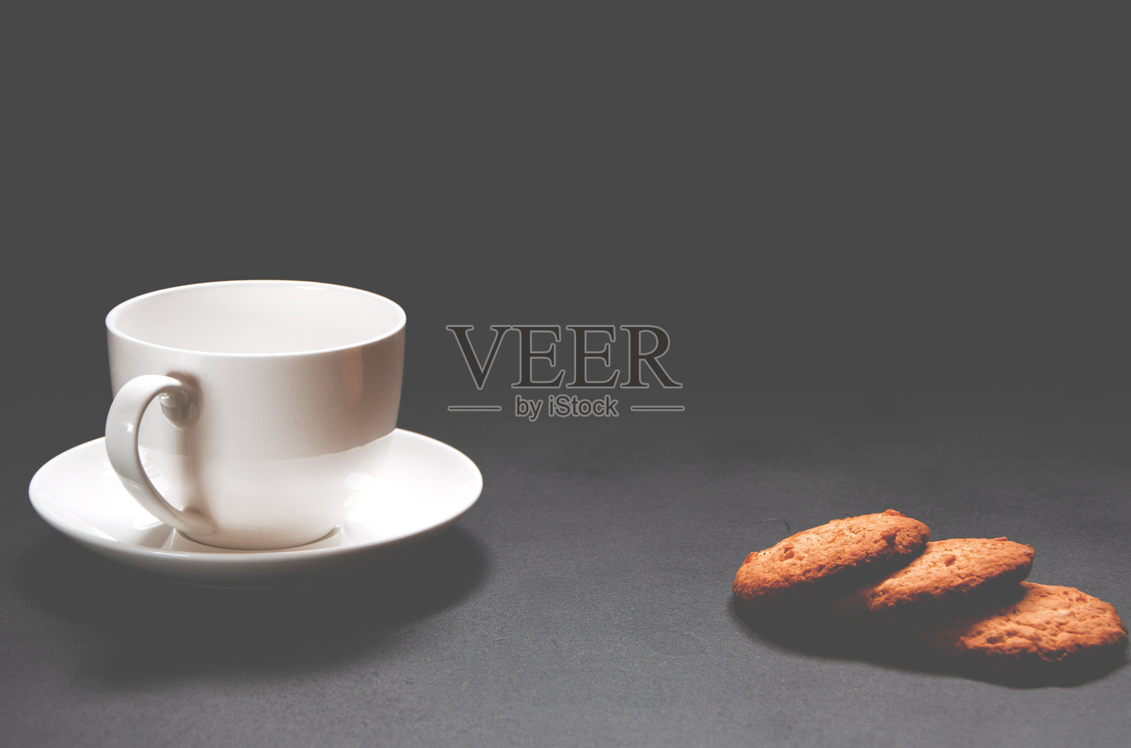 一杯白咖啡和自制的橘子饼干摆在黑咖啡上照片摄影图片