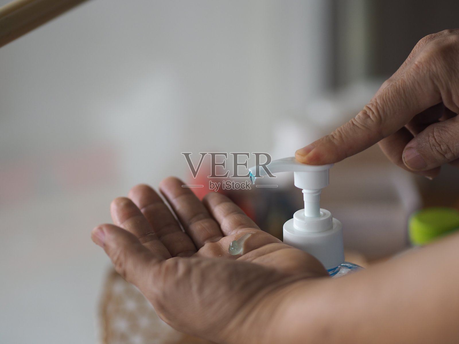 妇女站立并按压一个泵瓶,洗手液,凝胶酒精混合物与明胶在透明塑料瓶,洗干净脏,以防止细菌保护结肠病毒,冠状病毒19照片摄影图片