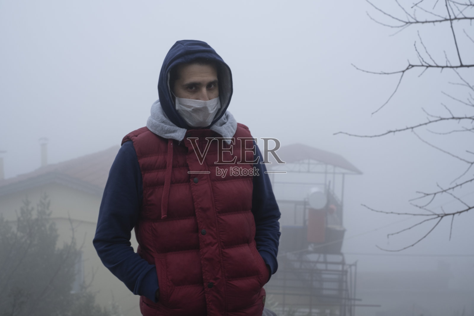 男人戴着口罩在雾天里看着镜头照片摄影图片