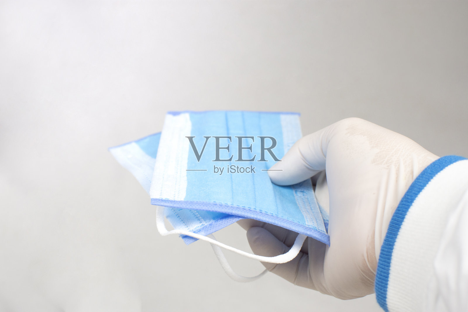 医生手中的医用口罩用于预防细菌、冠状病毒、Covid-19。照片摄影图片