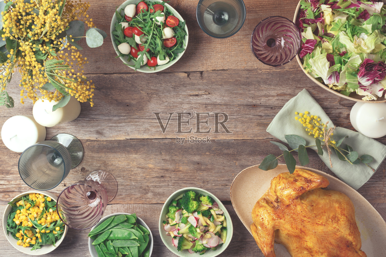 情人节,妇女节,母亲节,婚礼早午餐。节日家庭餐桌。盛有沙拉和蔬菜的盘子,碗,小吃,烤鸡,桉树,含苞欲放的木叶照片摄影图片