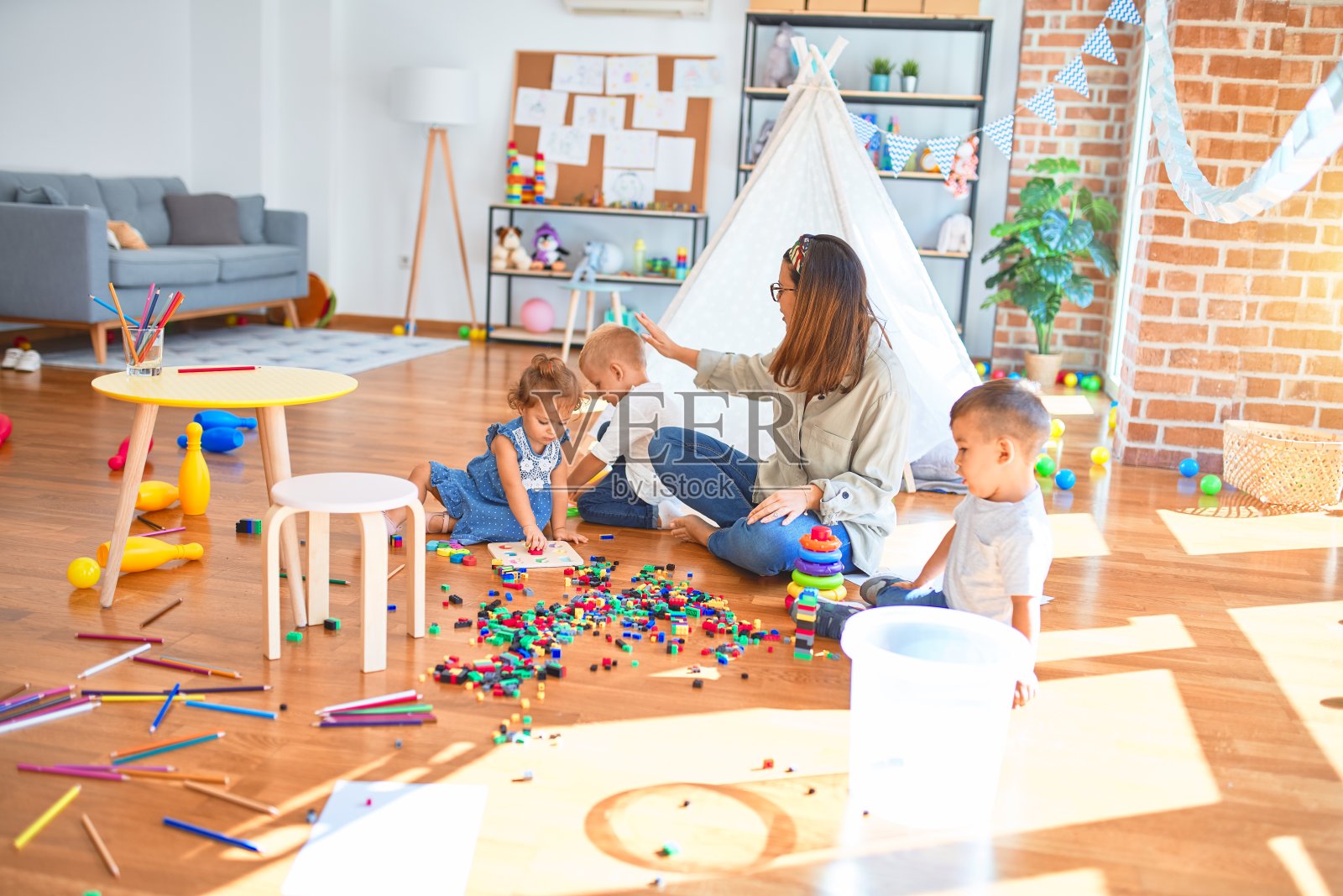 美丽的老师和一群幼儿在幼儿园玩玩具照片摄影图片