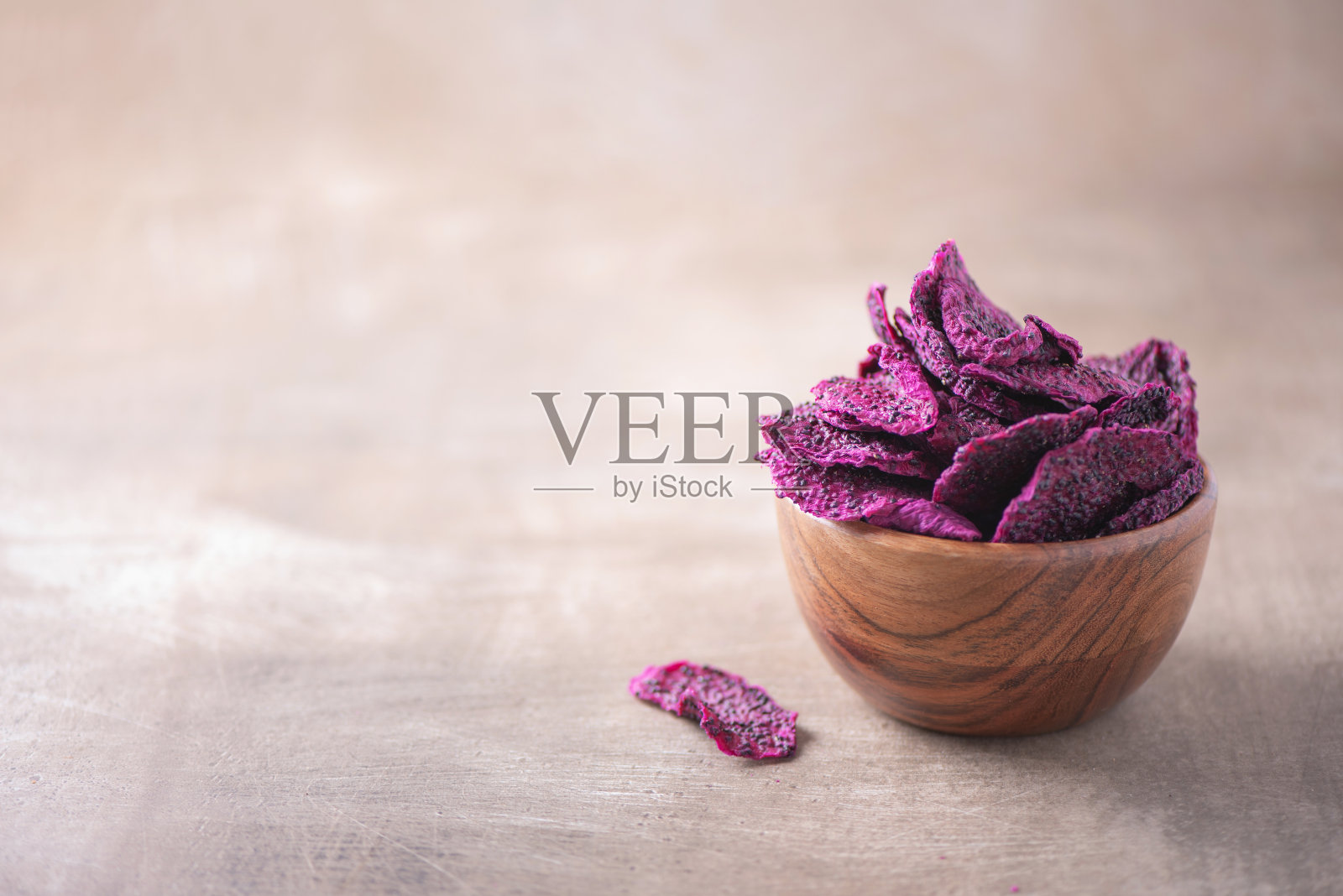 干火龙果片,火龙果置于木碗中,以木纹为背景。副本的空间。超级食物,素食,素食的概念。火龙果的宏观质地,选择性聚焦。健康的零食。照片摄影图片